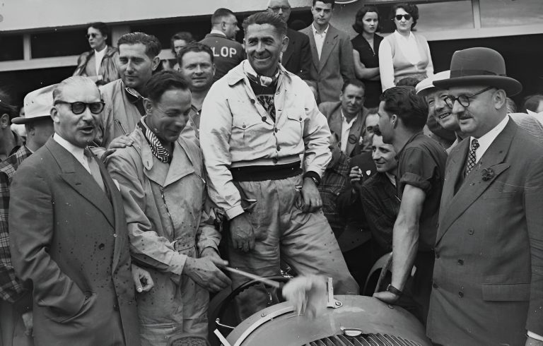 Louis Rosier surrounded by officials and well-wishers beside his car after the finish