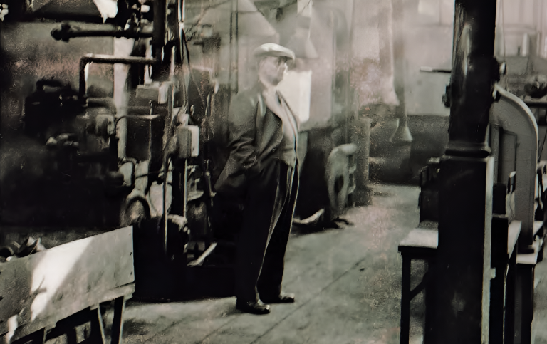 A lone figure standing among idle machinery in the Talbot-Lago works