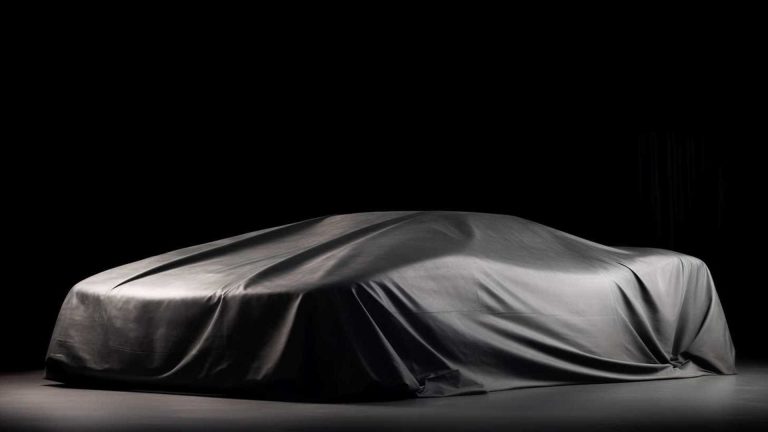 A hypercar silhouette beneath a silk cover, awaiting reveal